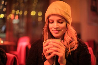 Sıcak çay fincan tutan güzel genç kadın