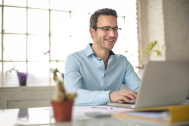 Bilgisayarıyla çalışan başarılı bir iş adamı.