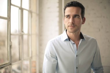 Pencereden dışarı bakan yakışıklı adam