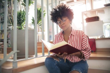 Kıvırcık saçlı güzel afro-amerikan kız okuma