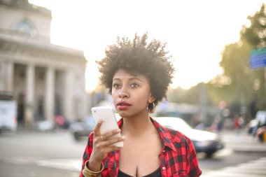 Akıllı telefon kullanarak kıvırcık saçlı güzel kız