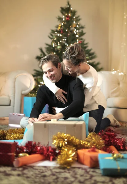 Sweet couple enjoying their Christmas holiday, wrapping up gifts