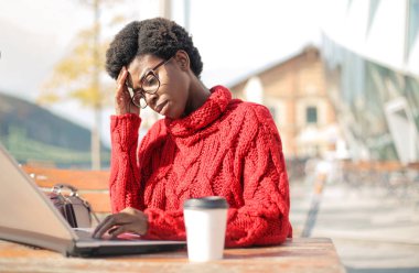 kafede dizüstü bilgisayar kullanarak güzel afro-amerikan kadın