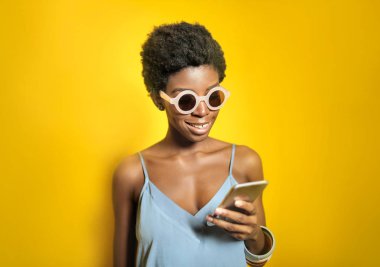 akıllı telefon kullanarak güneş gözlüğü güzel afrikalı amerikalı kadın