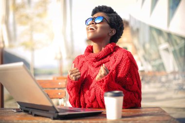 kafede dizüstü bilgisayar kullanarak güzel afro-amerikan kadın
