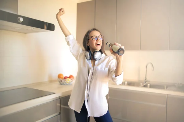 beautiful young woman singing in the kitchen