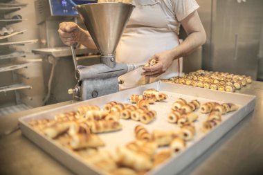Şef cannoli 'yi kremayla dolduruyor.