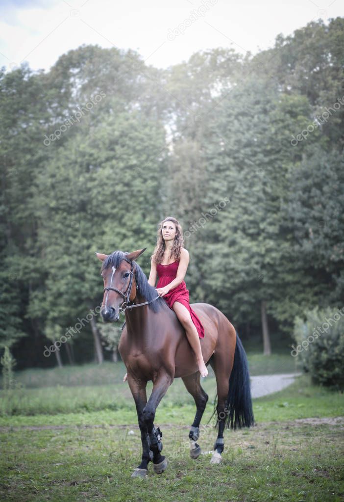 Beautiful brunette girl riding her horse