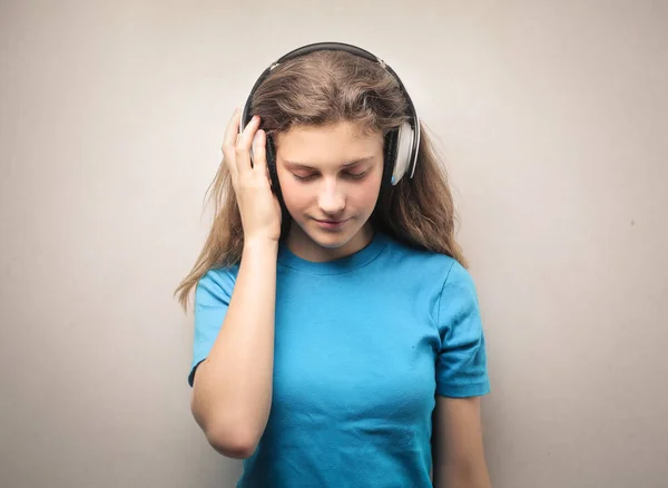 beautiful teenage girl in headphones against studio background