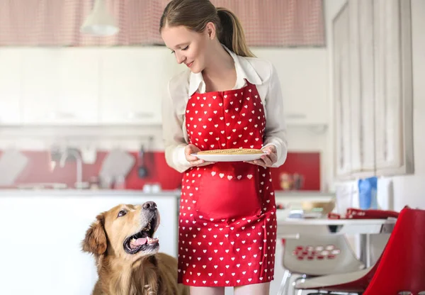 young beautiful woman with dog in the kitchen
