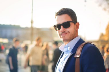 Güneş gözlüğü yakışıklı genç adam gülümsüyor