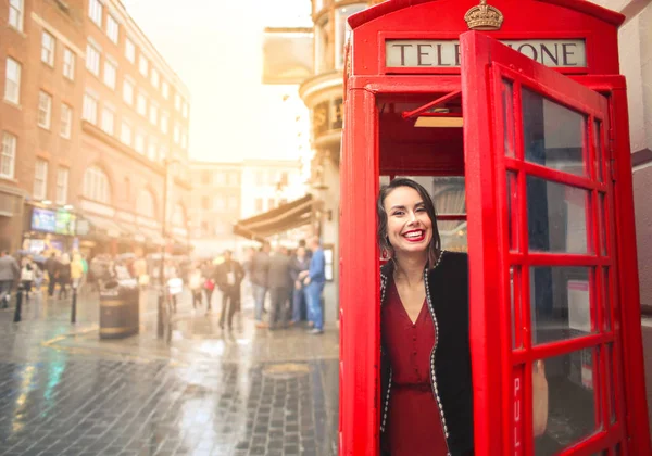 beautiful young woman in London telephone booth