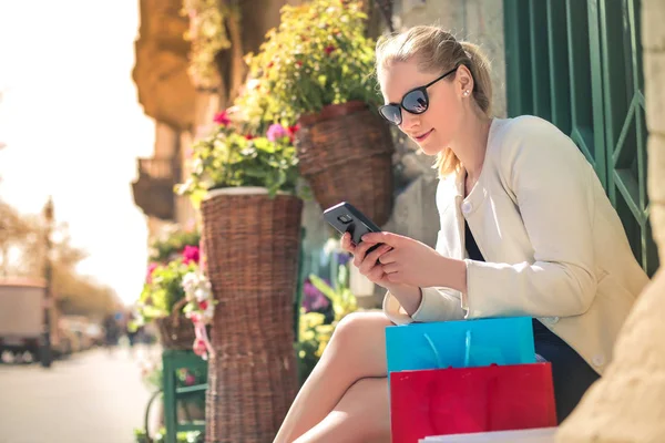 Mujer Rubia Joven Con Bolsas Compras Usando Teléfono Inteligente — Foto de Stock