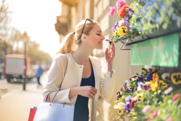 Joven Rubia Con Bolsas Compras Oliendo Flores — Foto de Stock