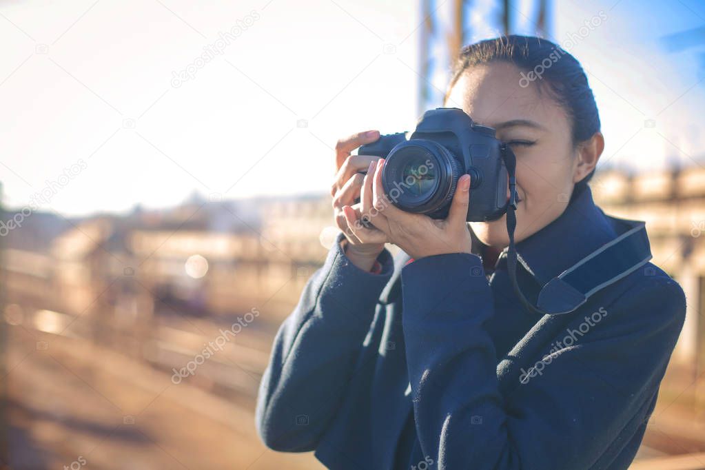 young brunette woman holding professional photo camera