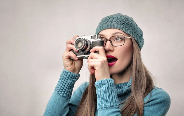 Beautiful young woman holding vintage camera