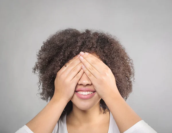 Cute girl covering her eyes with her hands