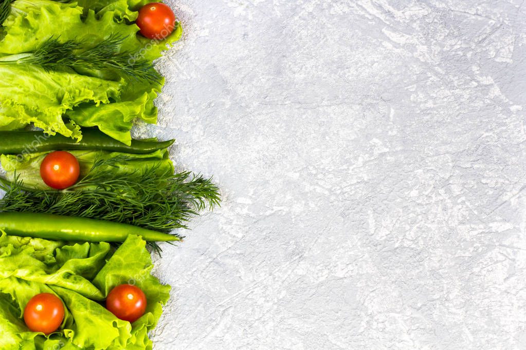 juicy greens and cherry tomatoes on a gray background