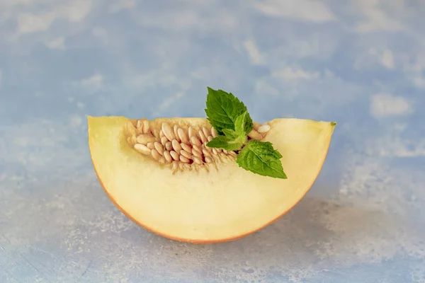 Reife frische gelbe Melone in Stücke geschnitten auf blauem Hintergrund — Stockfoto