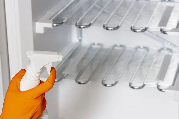 Female hand in protective gloves are wiping refrigerator — Stock Photo, Image
