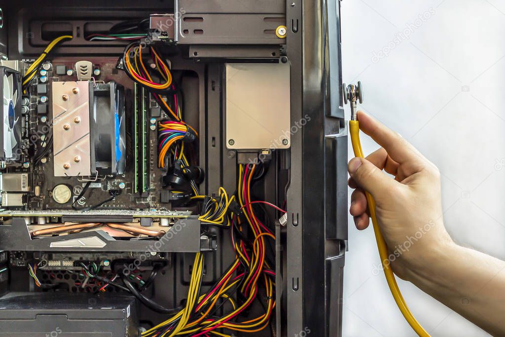 Male hand is holding a stethoscope over computer.