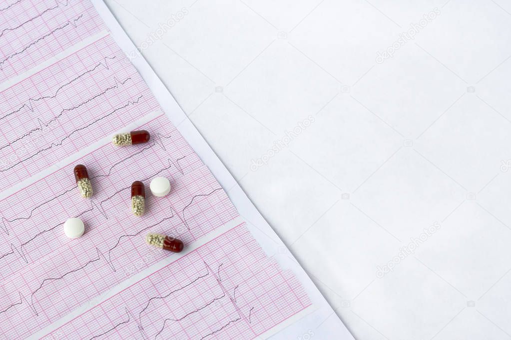 Cardiogram with a pills, tablets on a background 