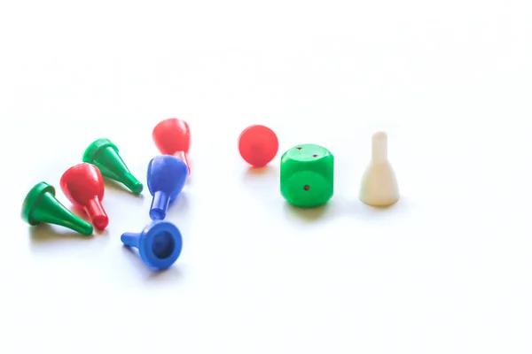 Colorful play figures and plastic chips with dice on white background. Board games for children and adults. Family and friendly pastime concept. Copy space for text