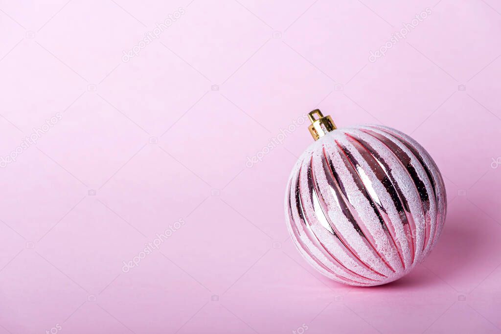 Christmas composition. Christmas pink bauble, shiny ball on pastel background. Mock up for new year gretting card. Close up, copy space for text or lettering