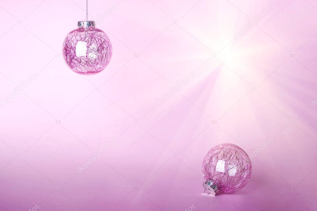Christmas composition. Two Christmas pink bauble, shiny balls hanging on pastel background. Mock up for new year gretting card. Close up, copy space for text or lettering