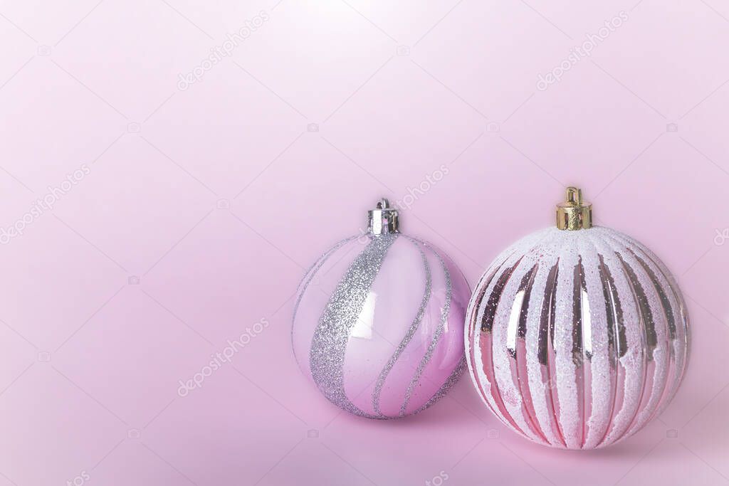 Christmas composition. Two Christmas pink bauble, shiny balls hanging on pastel background. Mock up for new year gretting card. Close up, copy space for text or lettering
