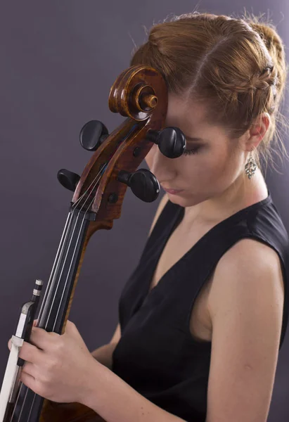年轻姑娘在黑暗中弹奏大提琴 塞浦路斯 — 图库照片