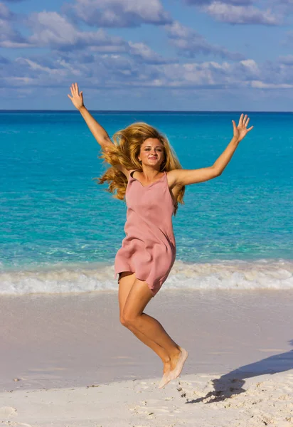 幸せな女の子はビーチでジャンプしています ビーチでの短いドレスの若い女性 — ストック写真
