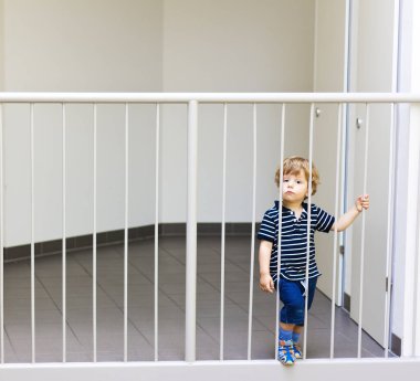 Küçük çocuk merdivenlerde duruyor.