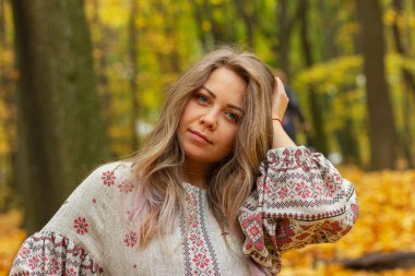 Sonbahar ormanında genç ve güzel bir kadın. 