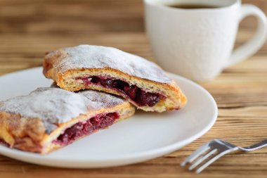 ahşap bir masa üzerinde bir fincan çay ile puf böreği gelen strudel dilimleri 