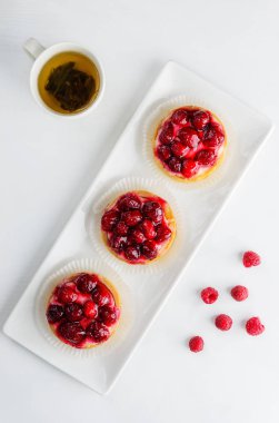 Beyaz bir tabak üzerinde ahududu ile Tartlets 