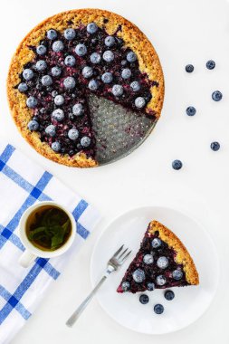 Siyah frenk üzümü ve yaban mersini ve bir fincan çay ile ev yapımı pasta -