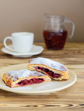 ahşap bir masa üzerinde bir fincan çay ile puf böreği gelen strudel dilimleri 