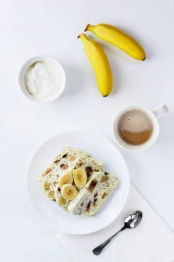 Muz lu süzme peynir güveci ve tepside bir fincan kahve