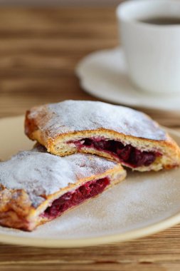 ahşap bir masa üzerinde bir fincan çay ile puf böreği gelen strudel dilimleri 