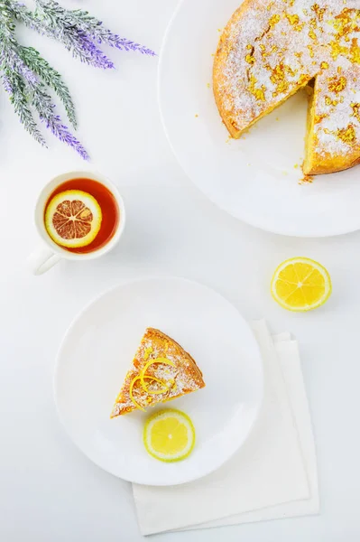 Lemon pie with a cup of tea on a white wooden table