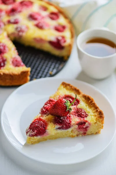 Scheibe Erdbeerkuchen Mit Einer Tasse Tee Auf Dem Tisch — Stockfoto