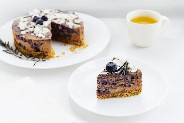 Blueberry - chocolate cheesecake on a white wooden table