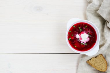 Borsch beyaz ahşap bir masa üzerinde bir tabak, kopya alanı ile. Geleneksel, ulusal Rus yemekleri.