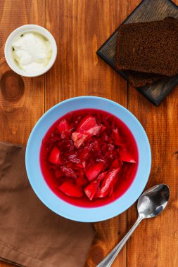 Borsch tahta bir masanın üzerinde bir tabakta. Geleneksel, ulusal Rus yemekleri.