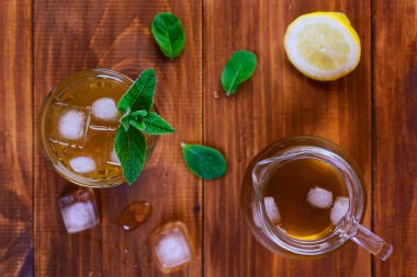 Ahşap bir masada limon, buz ve nane ile Kombucha çayı. Üstte görüntü.