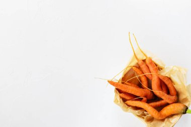 Beyaz bir arka planda bir kutuda çirkin havuç. Çirkin gıda kavramı, üst görünüm, kopya alanı.