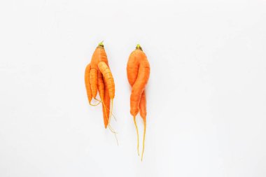 Beyaz bir arka planda çirkin havuç. Çirkin gıda kavramı, üst görünüm.