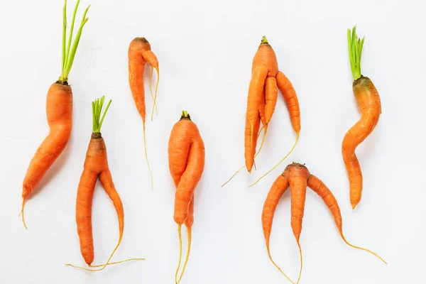 Ugly carrots on a white background. Ugly food concept, flat lay.
