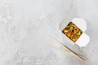 Gri bir arka plan üzerinde erişte kutusu. Asya mutfağı, yatay oryantasyon, düz yatıyordu, kopyalama alanı.